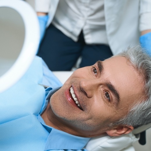 Man looking at his new smile after the four step dental implant process