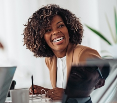 Woman smiling after replacing missing teeth