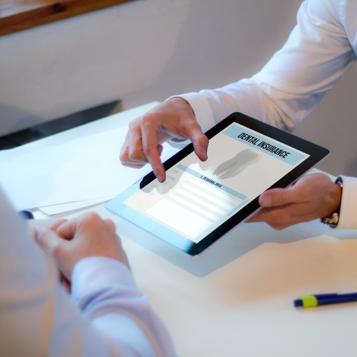 Dental team member and patient reviewing dental insurance coverage