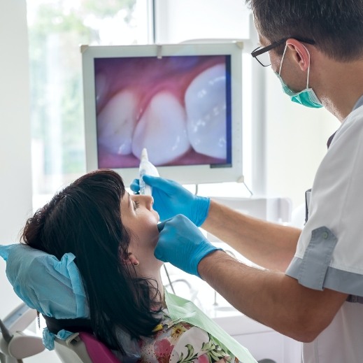 Dentist and patient looking at images produced by intraoral camera